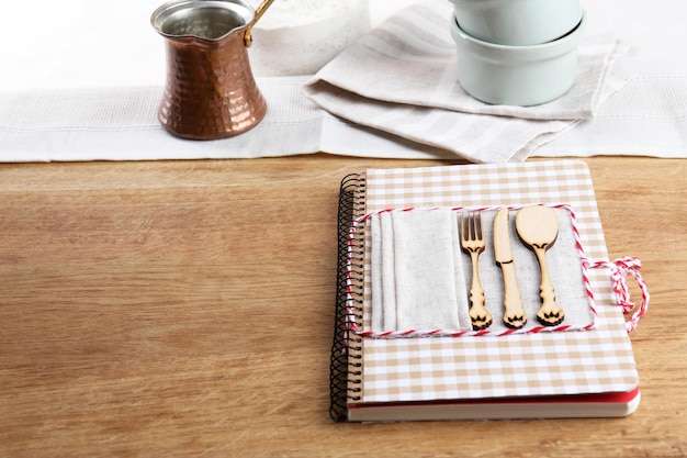 Recipe book at the kitchen on wooden background