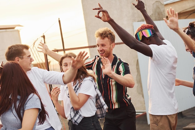 Recreation time Group of young people in casual clothes have a party at rooftop together at daytime