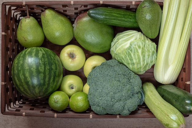 Rectangular basket with green fruit and vegetables watermelon apple pear mango lime cabbage