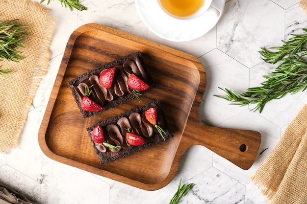 Rectangular chocolate tart with strawberry set in cafe table