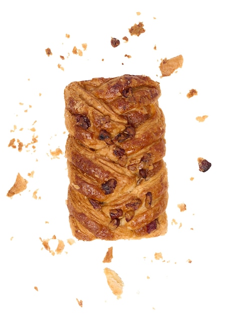 Rectangular pastry made from puff pastry with maple syrup and pecan nuts on a white background surrounded by crumbs