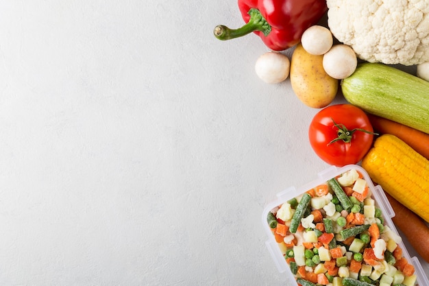 Rectangular plastic container with mix of frozen vegetables top view with copy space and fresh food