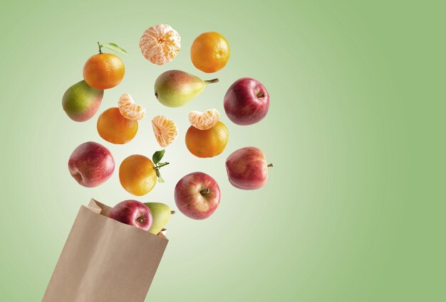 Recyclable paper bag with fresh fruits flying out