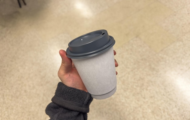 Photo recyclable paper cup a symbol of ecoconsciousness sits on green grass amid littered plastic high