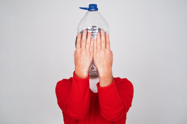 Recycle waste management concept Man hiding behind an empty water bottle