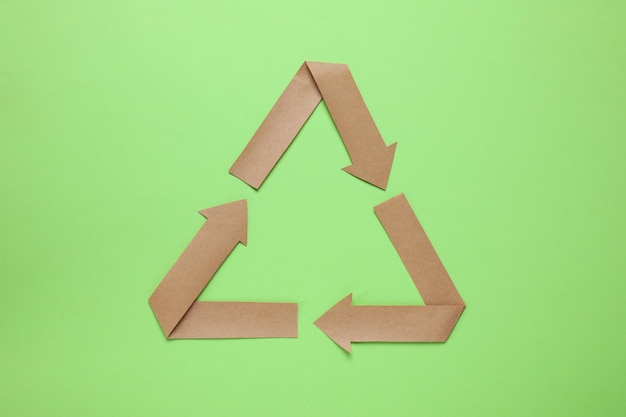 Photo recycling symbol cut out of paper on green background top view