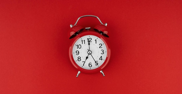 Red alarm clock on a red background Top view