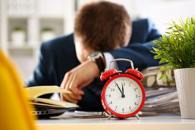 Red alarm clock shows late time closeup