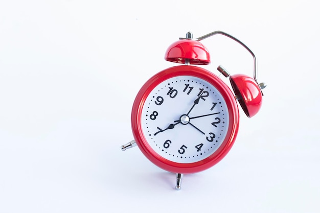 Red alarm clock on the white background. Close-up. Copy space.