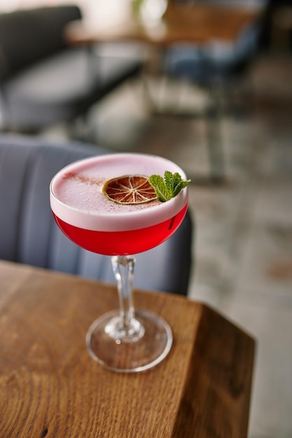 red alcoholic cocktail or lemonade with foam on the background of a beautiful restaurant