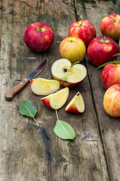 Red apple sliced and knife on old wooden table