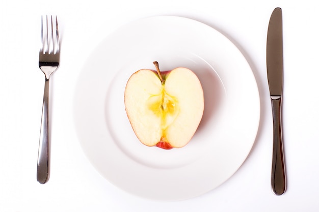 Red apple on white plate