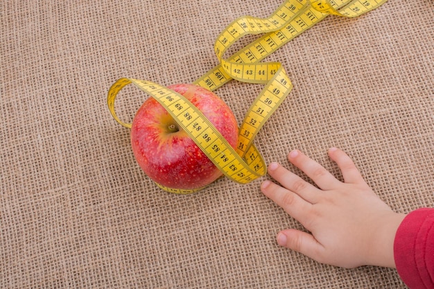 Red apple with a measurement tape on it