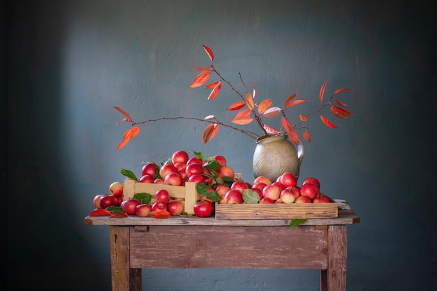 Red apples on old wooden table on background blue wall