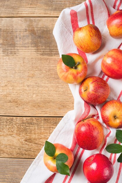 Red apples on table cloth frame over wooden