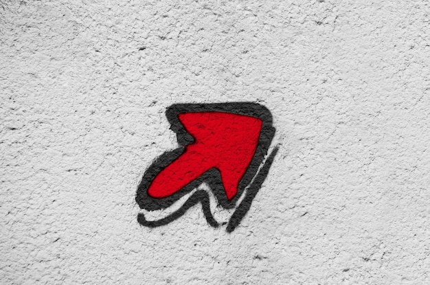 Photo red arrow on a gray old cracked wall background wall