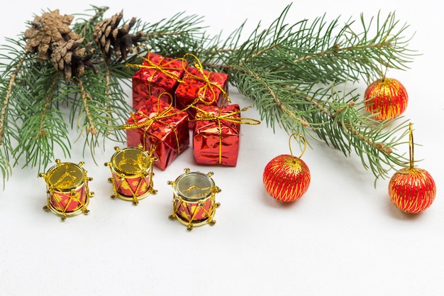 Red ball on fir branch. Christmas toys and fir branches on white surface. Copy space. Flat lay