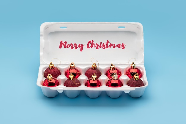 Red balls, Christmas tree decorations, in white egg packaging. Winter holidays, merry christmas.