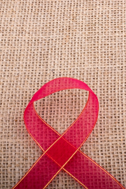 Red band ribbon on a brown color linen canvas