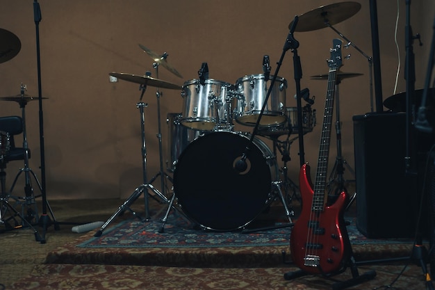 Red bass guitar on a home musical studio background