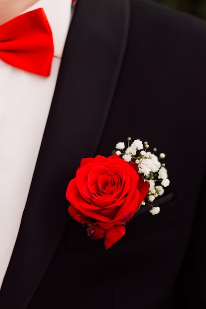 Red beautiful boutonniere on the grooms jacket