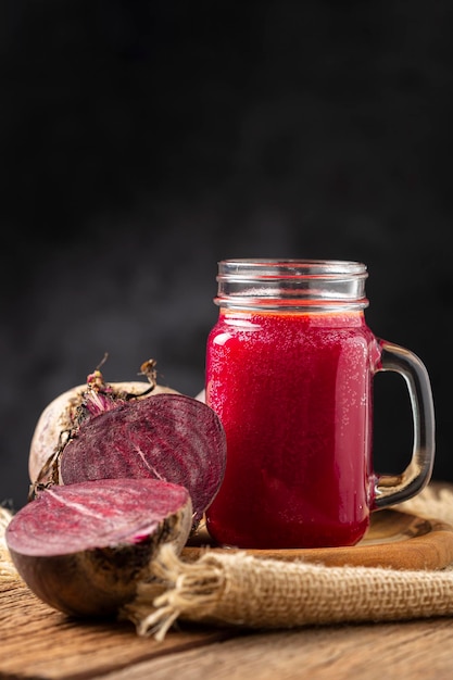 Red beet juice in a glass cup on the wooden table