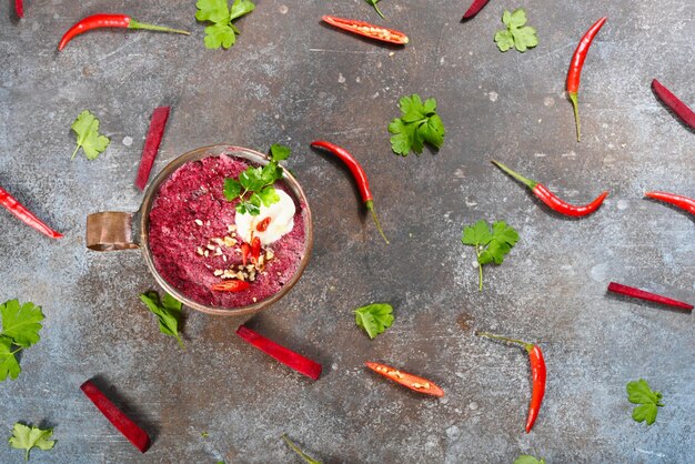 Red beet vegetarian soup in copper cup on dark background Horizontal