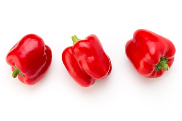 Red bell pepper with half and leaves isolated on white.