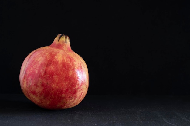 Red big pomegranate on dark background