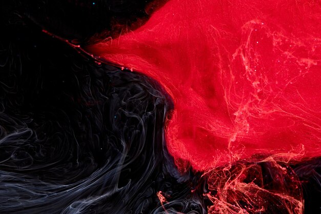 Red black abstract ocean background Splashes and waves of paint under water clouds of smoke in motion