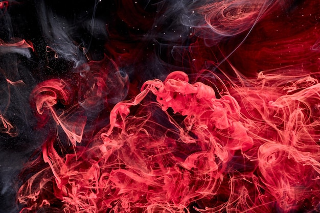 Red black abstract ocean background Splashes and waves of paint under water clouds of smoke in motion