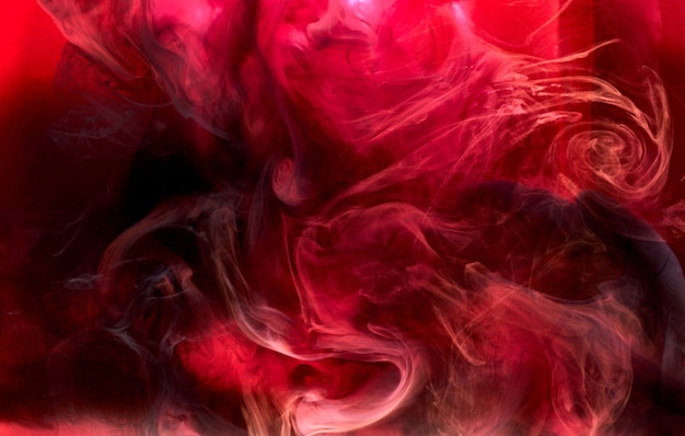 Red black pigment swirling ink abstract background, liquid smoke paint underwater