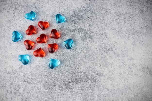 Photo red and blue decorative translucent hearts laid out in circles on gray surface