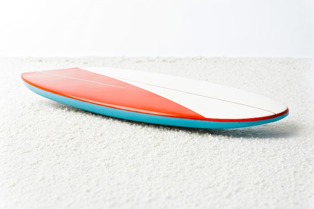 Photo red and blue surfboard on white sand