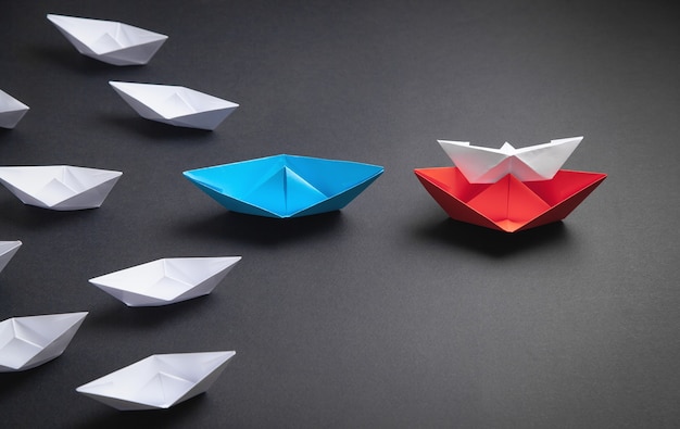 Red, blue and white paper boat. Leadership concept