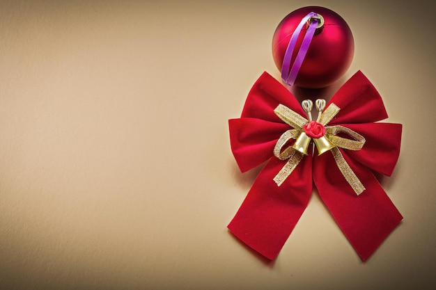 Red bow ball on golden background holidays concept