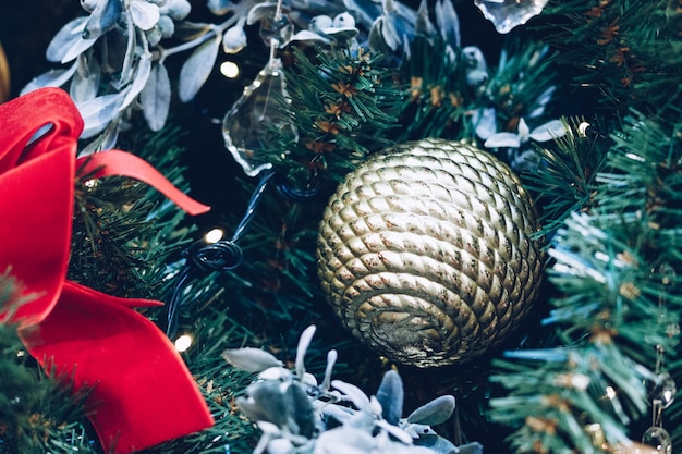 Red bow christmas balls and garlands on a christmas tree closeup