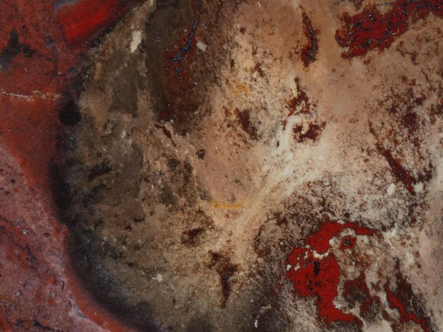 A red bowl with a dark red stain and a white spot on the bottom.