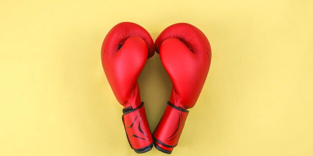 Red boxing gloves on yellow