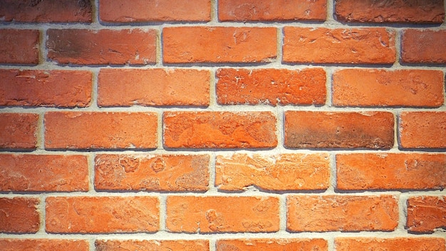 Red brick wall and old dirty rough surface texture close-up.