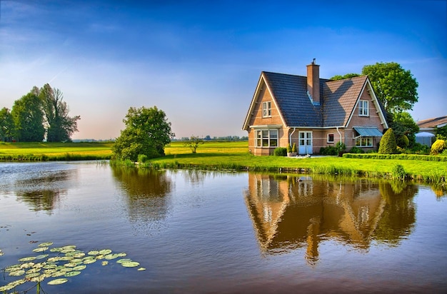 Red bricks house in countryside near the lake with mirror reflec