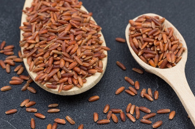 Red brown rice in wooden spoon.