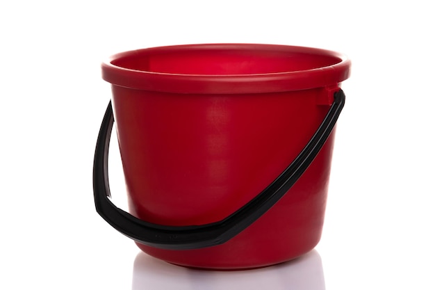 Red bucket plastic empty with black handle on white isolated background