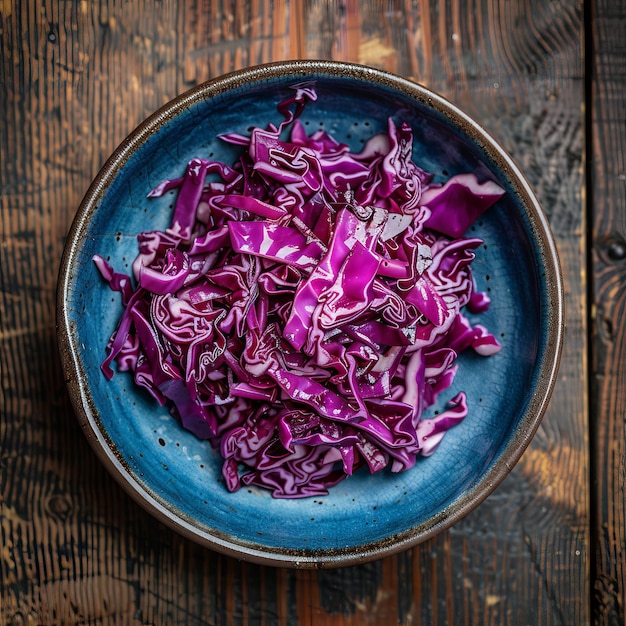 Photo red cabbage salad in blue bowl shredded purple cabbage on wooden table top view