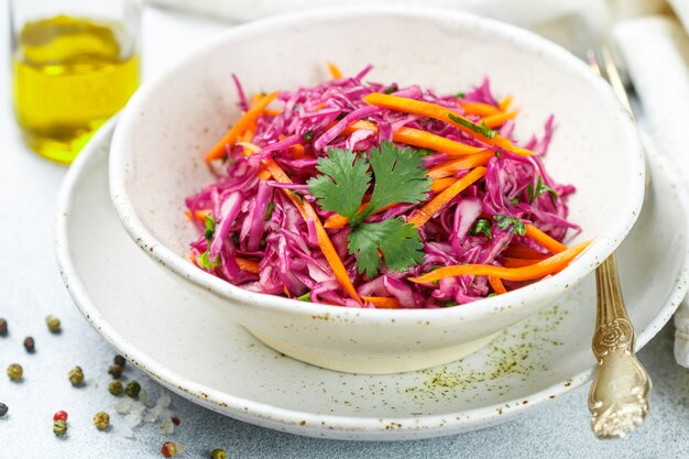 Photo red cabbage salad with carrots, herbs and olive oil and lemon juice dressing.  coleslaw. cole slaw