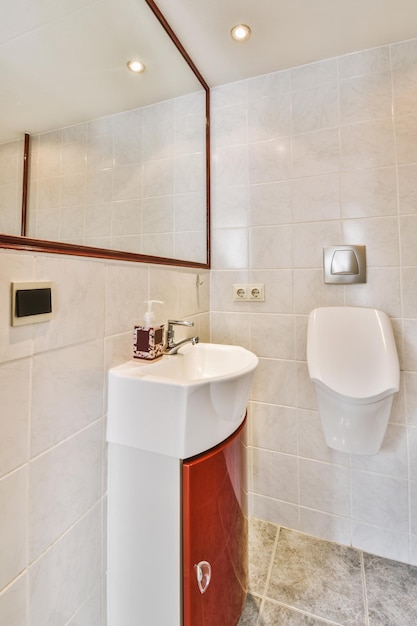 Red cabinet under the sink and mirror in the bathroom