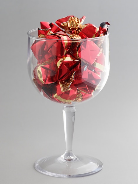 Red candies in a wine glass. Concept Christmas