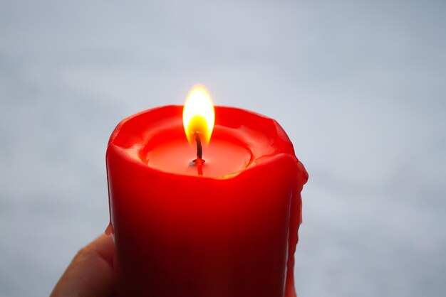 Red candle flame on fresh snow background