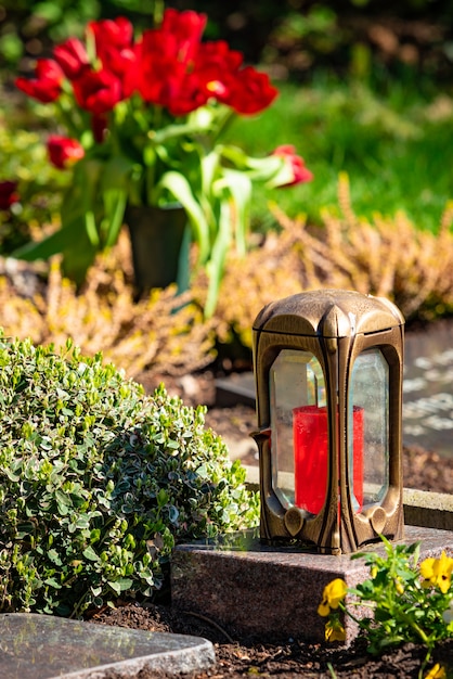 A red candle on the tombstones with flowers