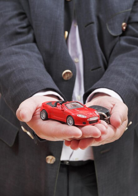 Photo red car and key in seller's hand